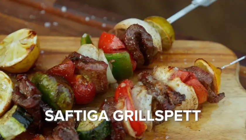 Saftiga grillspett med kött, grönsaker och citron på en träskärbräda. Perfekt för sommarens grillkvällar.