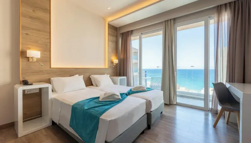 Pokój hotelowy z dwoma łóżkami i widokiem na morze. Idealne miejsce na relaks, jak w **pefkos**.