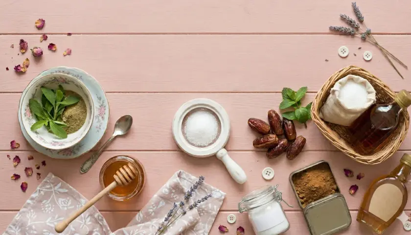 Stevia, miód, daktyle, cukier i syrop klonowy – co jest zdrowsze od cukru? Kompozycja na różowym tle.