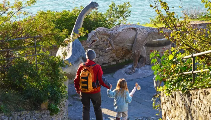 Un padre e una bambina esplorano dinosauri in Liguria, un'avventura indimenticabile per tutta la famiglia.