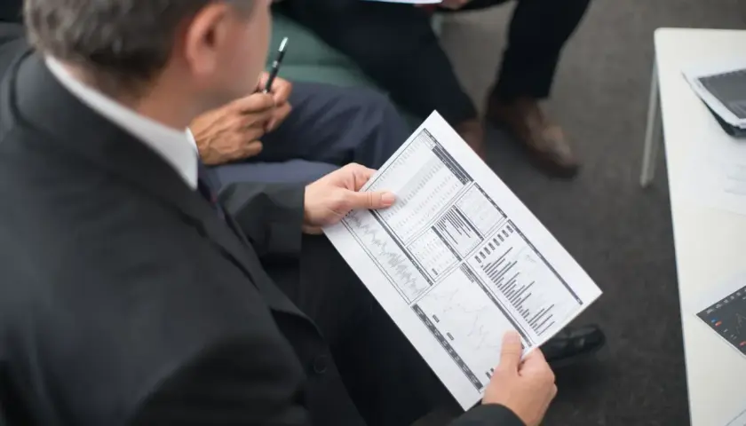 Biznesmeni analizują dokumenty, szukając informacji, jak znaleźć numer NIP.