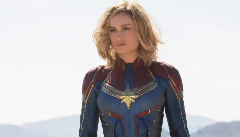 Captain Marvel, en armure bleue et rouge, prête à défendre la Terre. Elle est la réponse à qui est Captain Marvel.