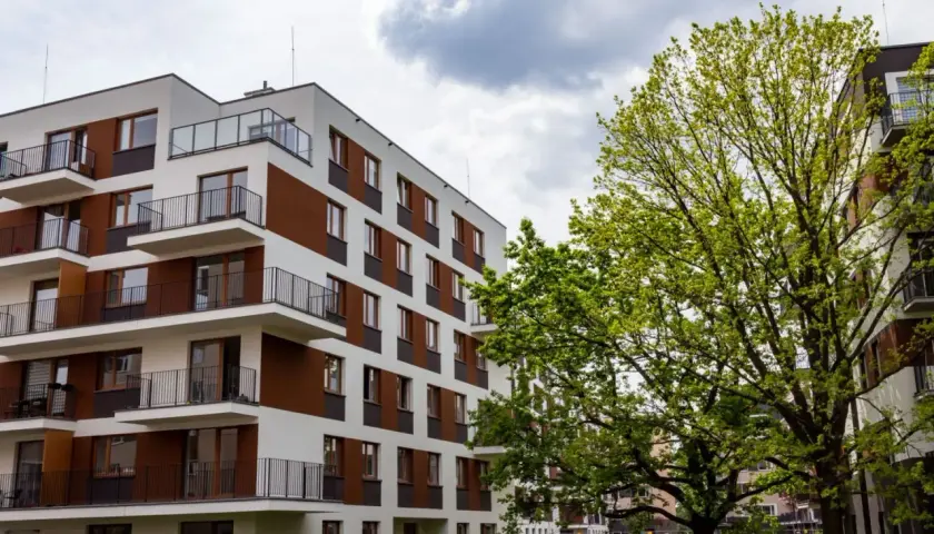 Nowoczesne bloki mieszkalne w stylu riviera park, z balkonami i zielenią.