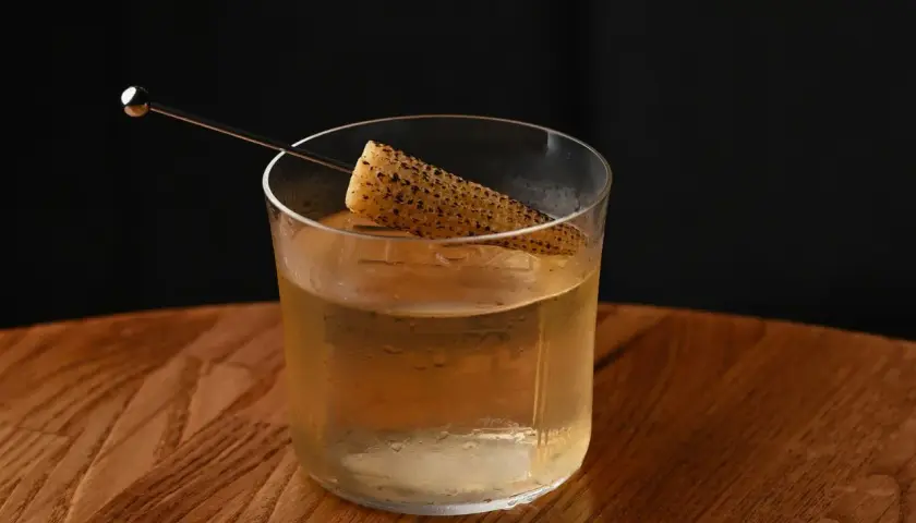 Szklanka z drinkiem i kawałkiem kukurydzy, intrygująca zapowiedź tego, jak smakuje brandy.