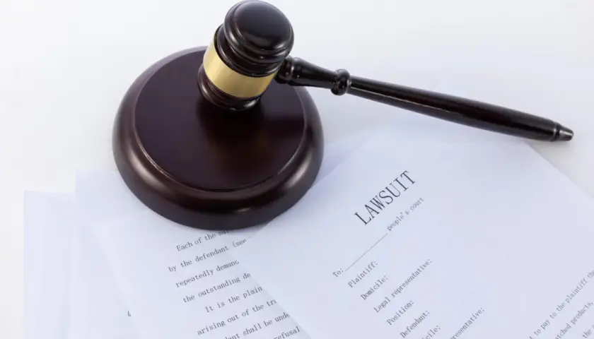 Młotek sędziowski na dokumentach z nagłówkiem "LAWSUIT". Wzór pozwu o alimenty, gotowy do wypełnienia.