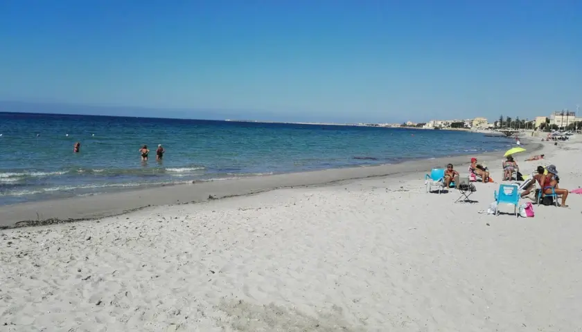 Plage de Mazara del Vallo, Italie. Des baigneurs profitent de la mer calme et du soleil sur le sable fin.