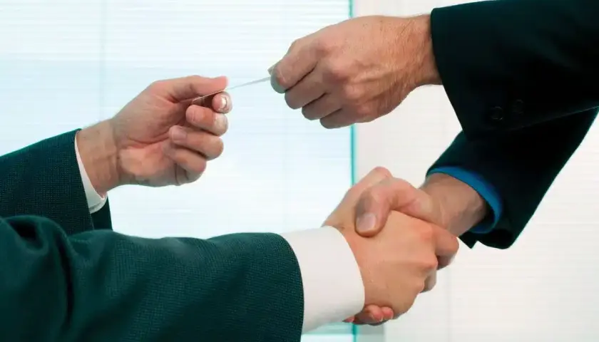 Dwóch biznesmenów wymienia się wizytówkami, co to jest wiron? To symbol nawiązywania kontaktów i współpracy.