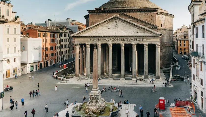 La Piazza della Rotonda à Rome, avec le majestueux Panthéon et sa fontaine. Des passants profitent de la journée ensoleillée.