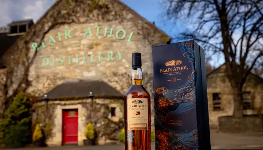 Bouteille de whisky Blair Athol 20 ans et sa boîte devant la distillerie.