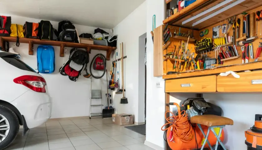 Werkstatt einrichten: Ordnung im Garage mit Werkzeugwand, Kompressor und Auto.