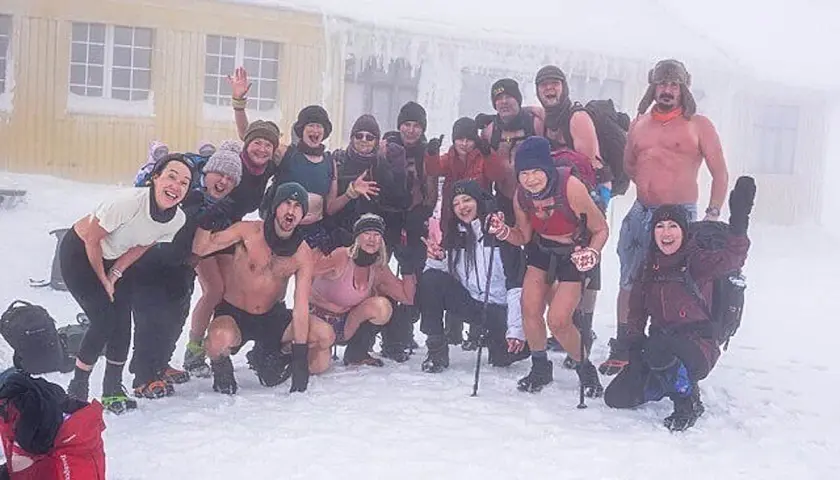 Grupa entuzjastów morsowania w stylu Wim Hof Polska pozuje do zdjęcia na mrozie.