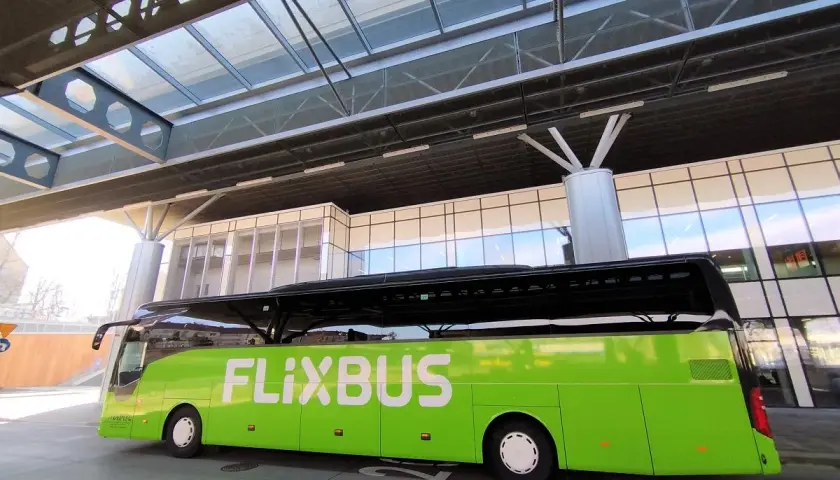 Zielony autobus FlixBus czeka na pasażerów na nowoczesnym dworcu. To idealne miejsce na rozpoczęcie podróży, bo flixbus przystanki są dobrze zorganizowane.