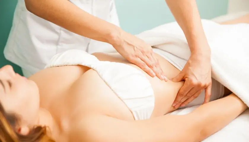 Drenaż limfatyczny brzucha. Delikatne ruchy dłoni terapeuty poprawiają krążenie i przynoszą widoczne efekty.