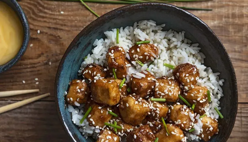 Pyszny stir fry z tofu, podany z ryżem i posypany sezamem. Idealny posiłek dla wegan.