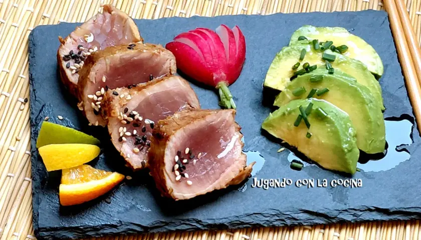 Tataki de bonito sellado con sésamo, acompañado de aguacate, rábano y cítricos.