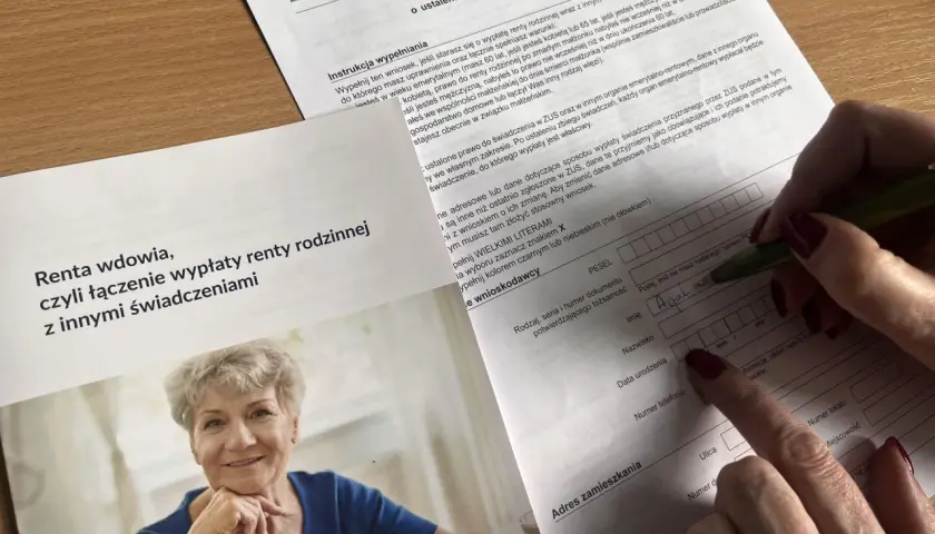 Wniosek o zbieg świadczeń z rentą rodzinna. Kobieta wypełnia dokument ZUS, by połączyć rentę rodzinną z innymi świadczeniami.