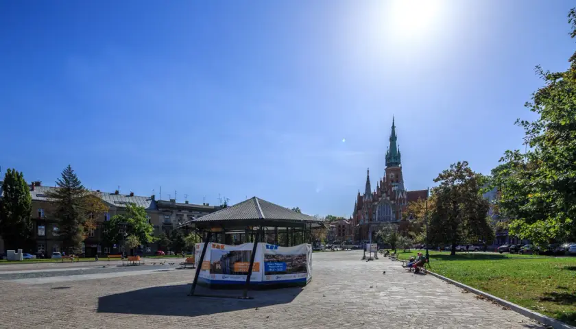 Słoneczny dzień na rynku podgórskim. W tle kościół św. Józefa, z przodu pawilon wystawowy.