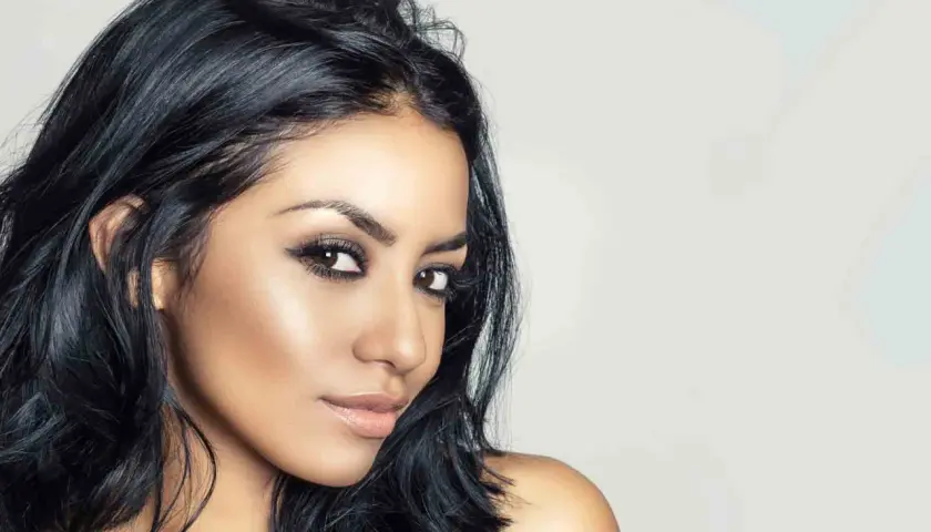 Mujer con piel morena, ojos marrones y cabello negro azabache. Un color de pelo para piel morena que realza su belleza natural.