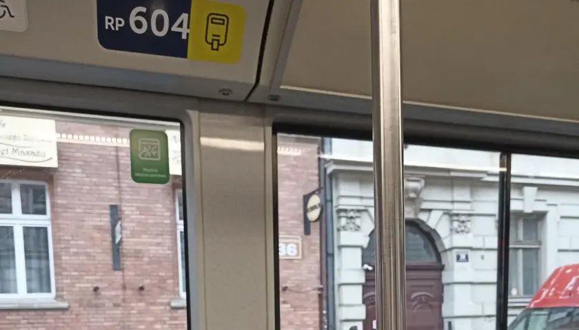 Numer boczny pojazdu kraków RP 604. Widok z okna tramwaju na zabytkową kamienicę.