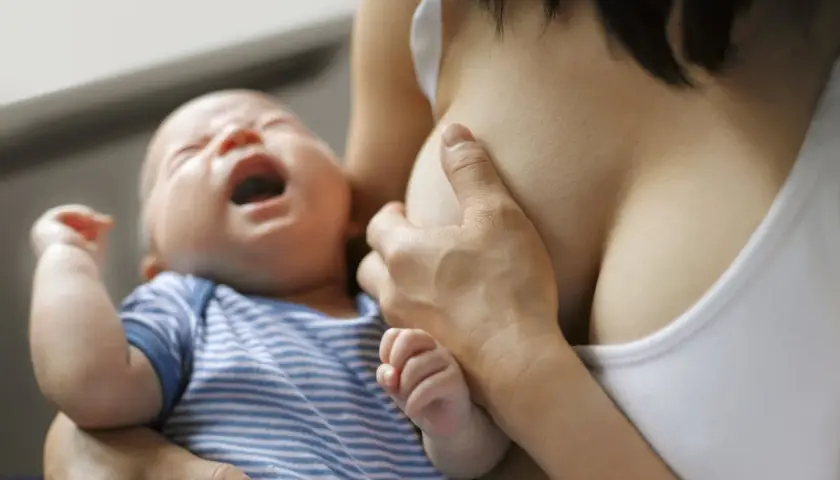 Bébé pleure pendant l'allaitement, possible signe de mastite infectieuse.