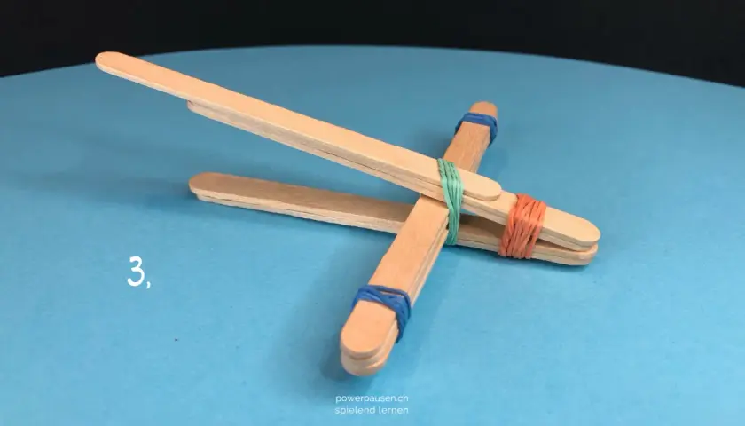 Schritt 3: Eine einfache Steinschleuder basteln aus Eisstielen und Gummibändern.