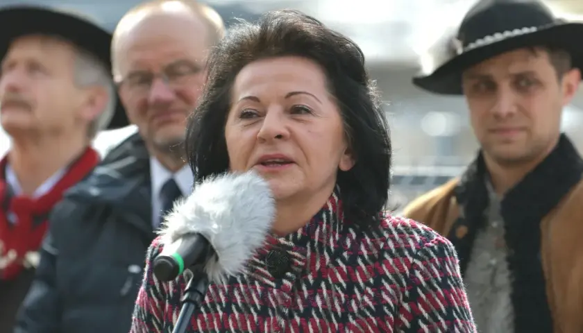 Kobieta przemawia do mikrofonu, w tle mężczyźni. Czy to ukryty majątek w nieruchomościach znanej posłanki Prawa i Sprawiedliwości?