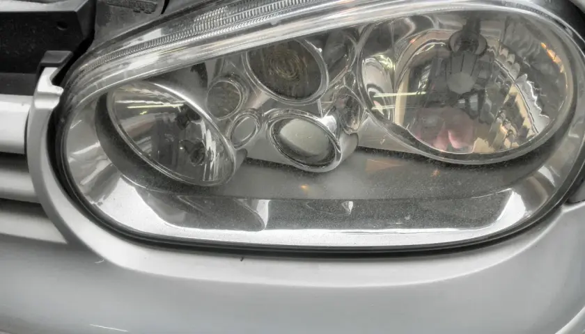 Reflektor przedni Golf 4, widoczne żarówki. Czysty klosz, gotowy do jazdy.