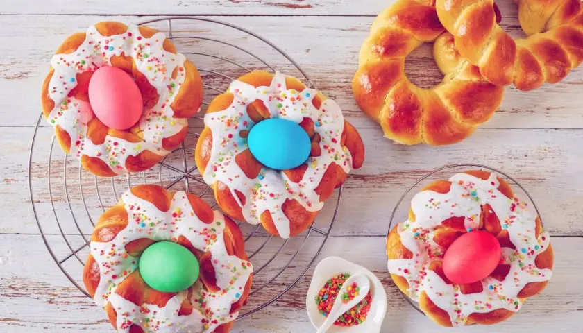 Bunte Osternester backen: Hefezöpfe mit Zuckerguss, Streuseln und gefärbten Eiern.