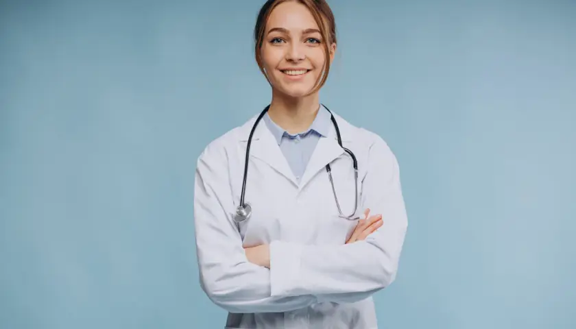 Uśmiechnięta lekarka w białym kitlu ze stetoskopem, zastanawia się, ile zarabia psychiatra.