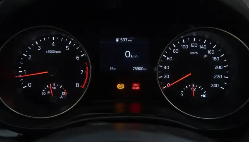 Cruscotto auto con tachimetro, contagiri e indicatori. La spia freni è accesa, segnalando un potenziale problema.