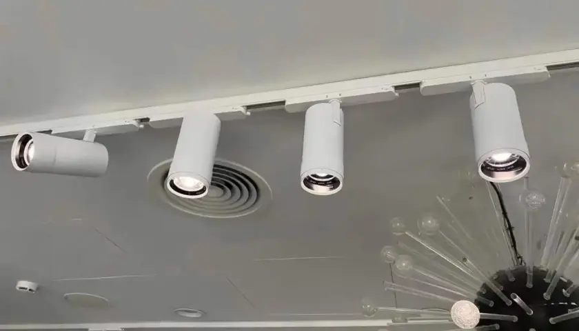 Barra focos techo blanca con focos cilíndricos dirigibles, iluminando un espacio moderno.
