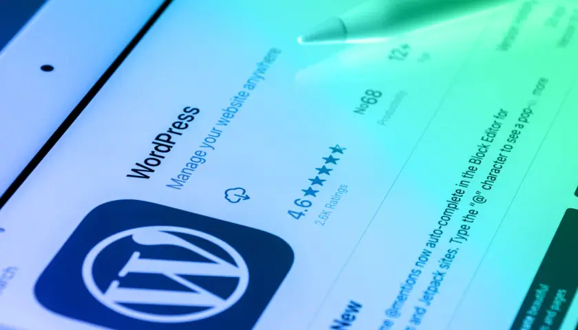 Ekran aplikacji WordPress na tablecie z rysikiem.