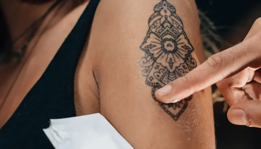 Application d'une crème sur un nouveau tatouage. Pour savoir si un tatouage est cicatrisé, observez la peau : elle ne doit plus être rouge, gonflée ni suinter.
