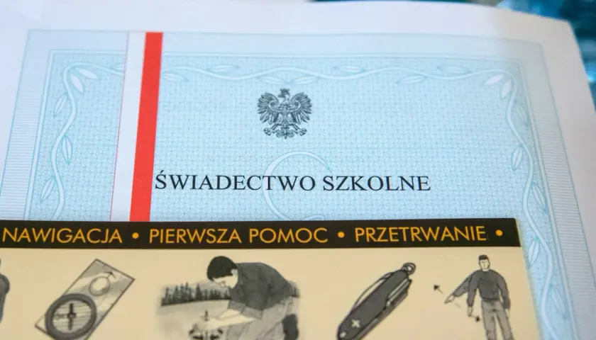 Świadectwo szkolne z godłem Polski i paskiem w barwach narodowych. Poniżej widoczne grafiki: kompas, pomoc, nóż i przetrwanie.