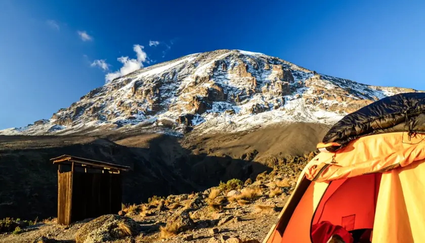 Zelt und Holzhütte am Kilimandscharo. Die beste Reisezeit Tansania ist ideal für dieses Abenteuer.