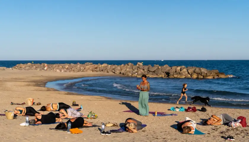 Cours de yoga sur la plage de Frontignan avec vue sur la mer et les étangs.