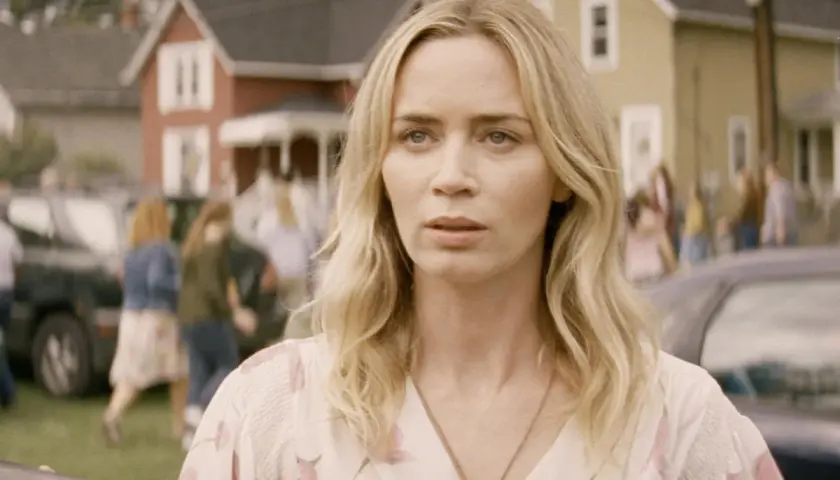 Emily Blunt i en scen från filmer med emily blunt. Hon ser orolig ut medan folk rör sig i bakgrunden.
