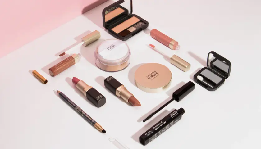 Annemarie Börlind Make-up: Lippenstifte, Lipgloss, Mascara, Lidschatten, Puder und Eyeliner auf weißem Hintergrund.