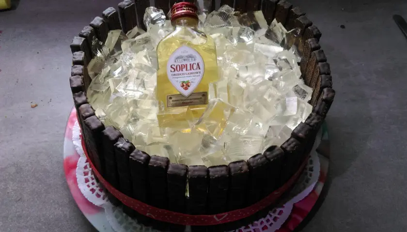 Oto pomysł, jak zrobić tort z butelek alkoholu: czekoladowe paluszki otaczają galaretkę z butelką Soplicy Orzech L răspasowy.