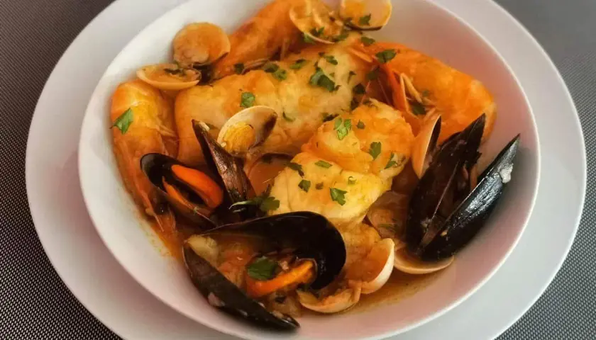 Caldereta de pescado con gambas, mejillones y almejas, todo ello espolvoreado con perejil fresco.