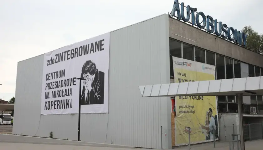 Budynek dworca autobusowego z banerem "zdeZINTEGROWANE CENTRUM PRZESIADKOWE IM. MIKOŁAJA KOPERNIKA".