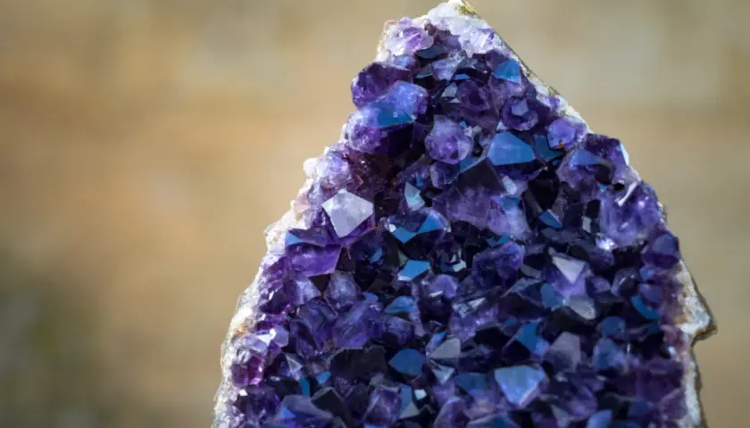Ein glitzernder Amethyst Edelstein mit tiefvioletten Kristallen, der wie ein Schatz aus einer anderen Welt wirkt.