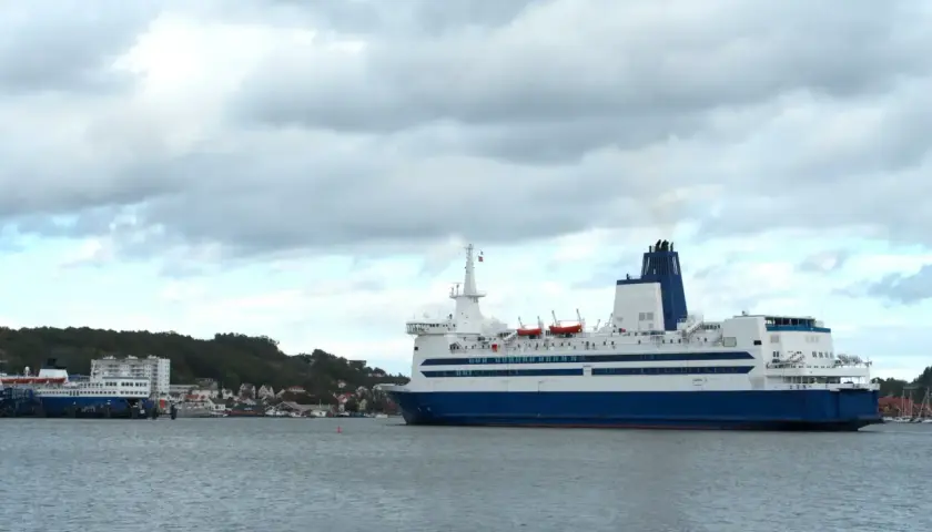 Duży prom pasażerski, podobny do tych kursujących na trasie Dover, zacumowany przy brzegu.