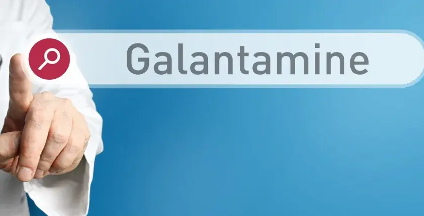 Lekarz w białym kitlu wskazuje palcem na pole wyszukiwania z napisem "Galantamine". Nivalin to nazwa handlowa leku zawierającego galantaminę.