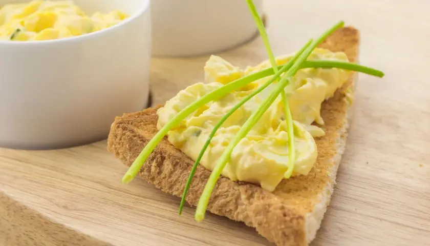 Fetta di pane tostato con salsa bolzanina ricetta, guarnita con erba cipollina. Cremosa e invitante, perfetta per un aperitivo.