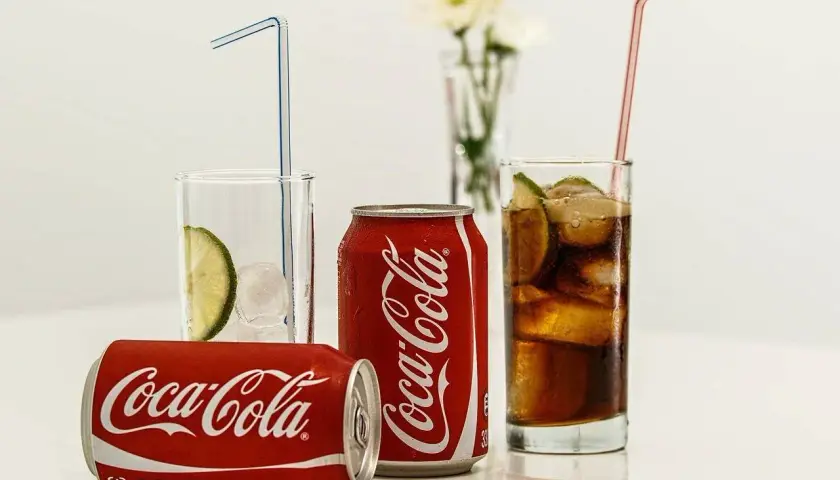 Puszki i szklanki z Coca-Colą, lodem i limonką. Zastanawiasz się, ile kalorii ma Coca-Cola?