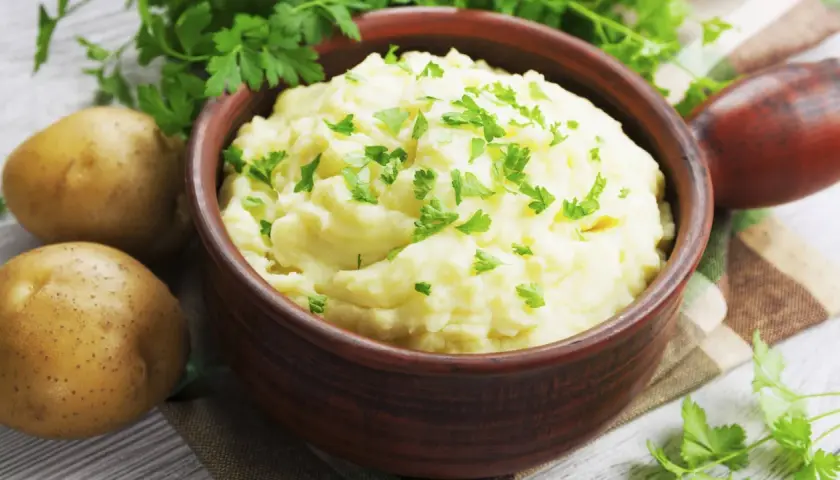 Un cremoso puré de patatas, un acompañamiento perfecto, adornado con perejil fresco.