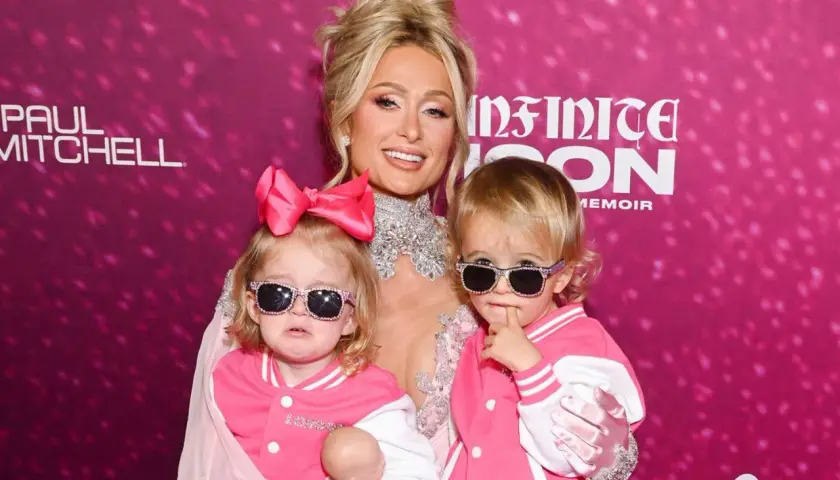 Paris Hilton z dwójką uroczych dzieci, obie w różowych kurtkach i okularach przeciwsłonecznych.
