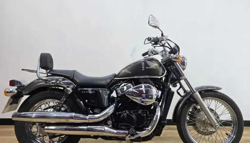 Honda VT750S cromata e scura, con sella nera e schienalino per il passeggero.