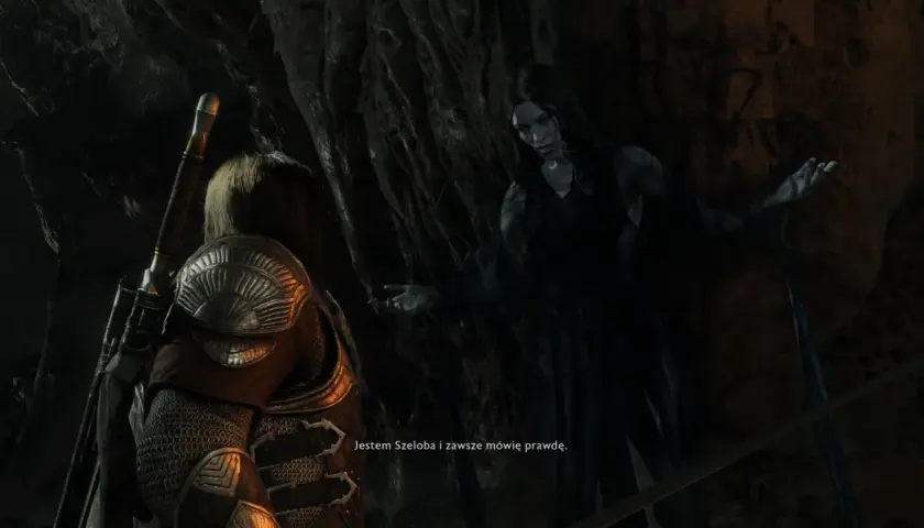 Szeloba, widmowa postać z gry Shadow of War, przemawia do bohatera w mrocznej jaskini.